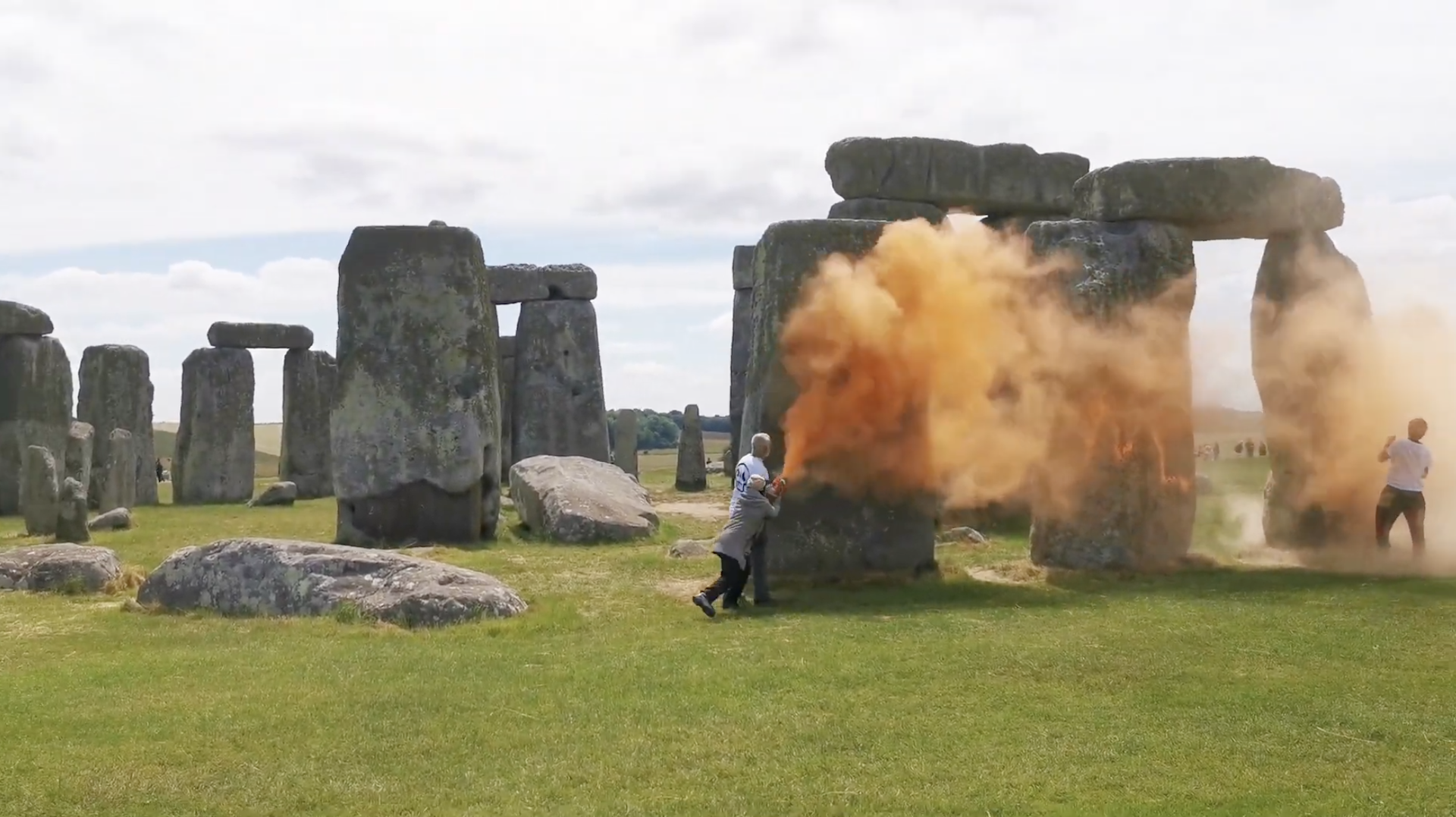 two protesters spray orange substance onto Stonehenge stones. two protesters spray orange substance onto Stonehenge stones.
