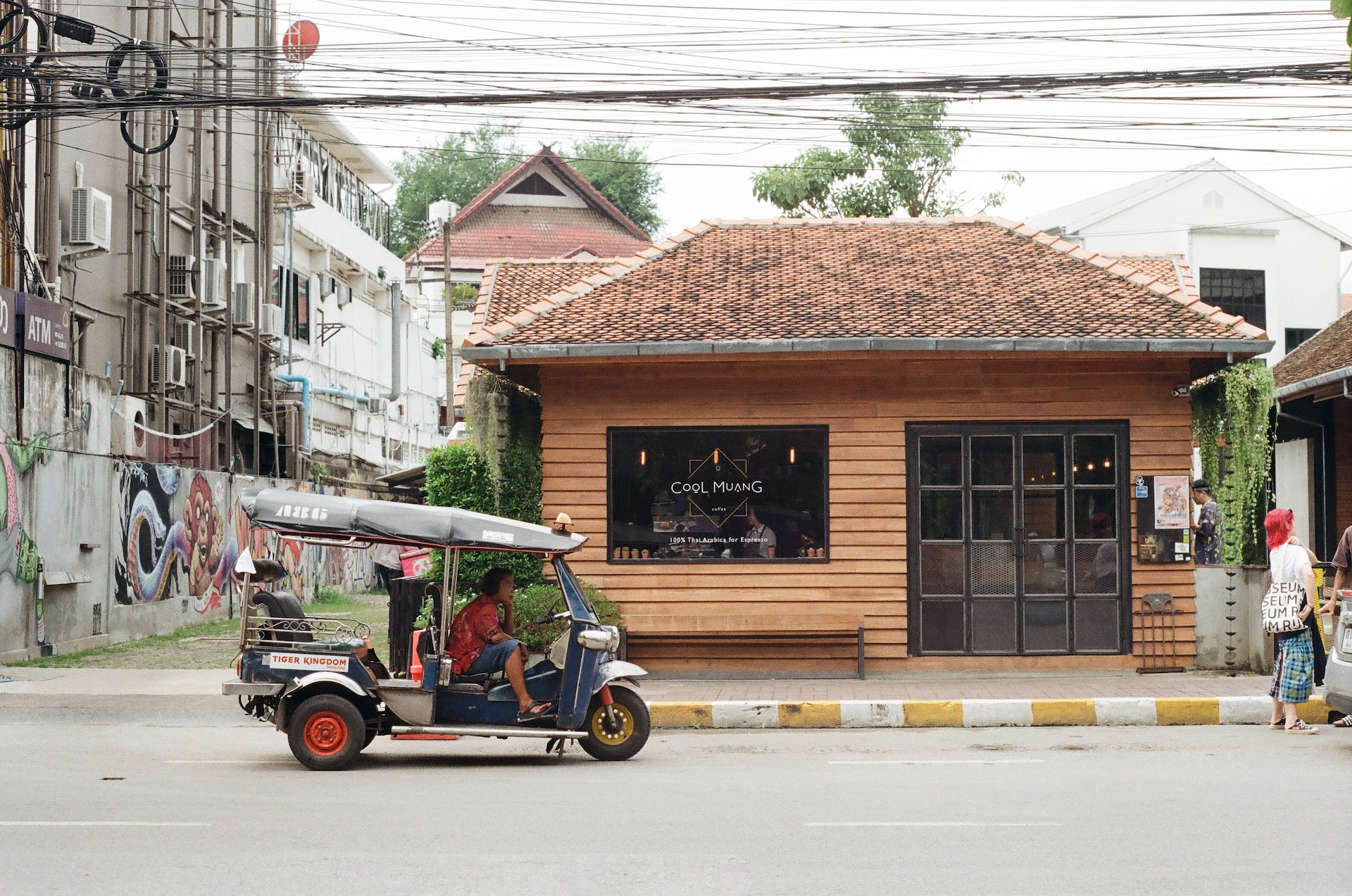 A coffee shop and a small vehicle in a Thai city. A coffee shop and a small vehicle in a Thai city.