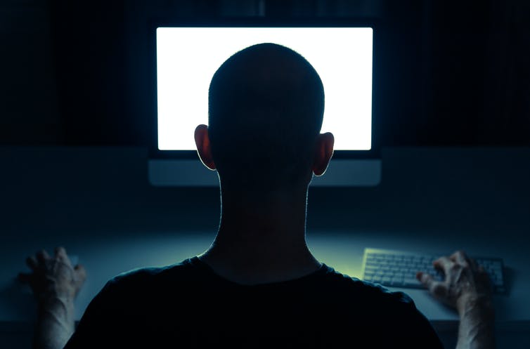 Picture of a man from behind staring at a computer screen. Picture of a man from behind staring at a computer screen.