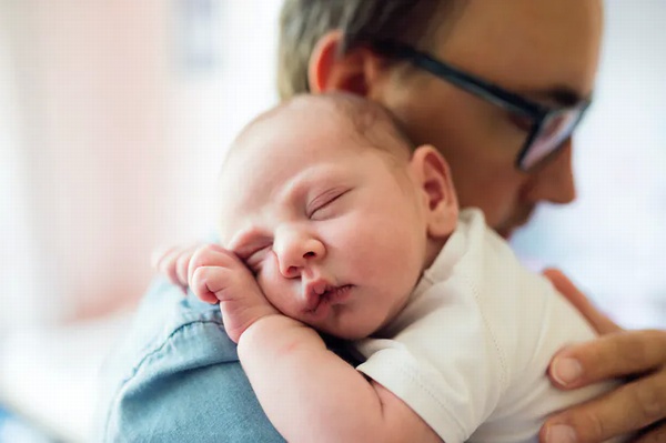 Close up of young father holding his newborn baby son Close up of young father holding his newborn baby son
